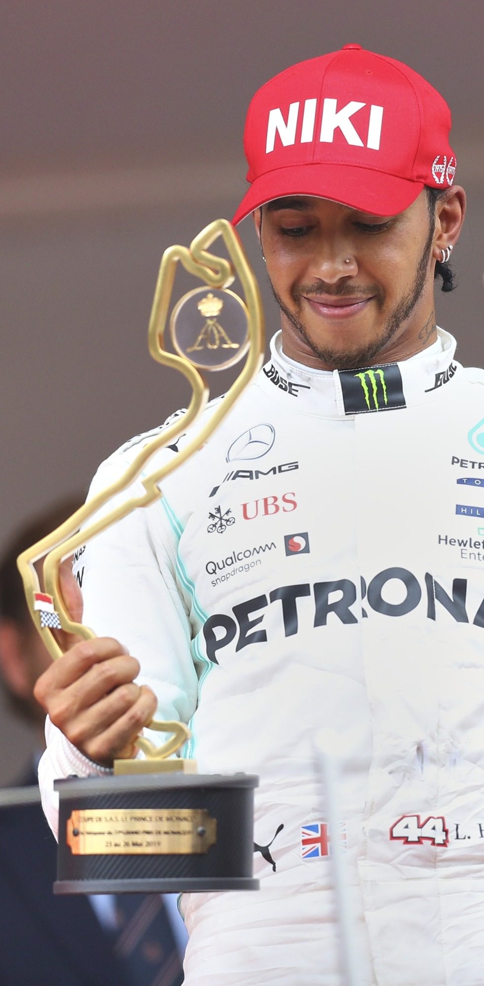 Lewis Hamilton holding Monaco GP trophy, wearing NIKI tribute cap